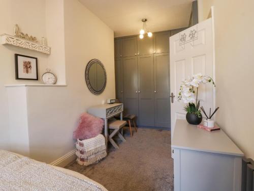 a bedroom with a bed and a desk and a mirror at 15 Clitheroe in Skipton