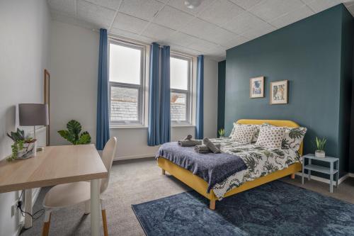 - une chambre avec des murs bleus, un lit et une table dans l'établissement 2 Bed-Town Centre-Free Parking, à Old Walker