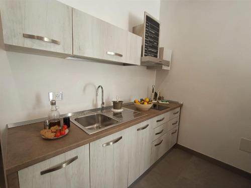 eine Küche mit Spüle und eine Schale mit Obst auf der Theke in der Unterkunft Civico 72 in Martano