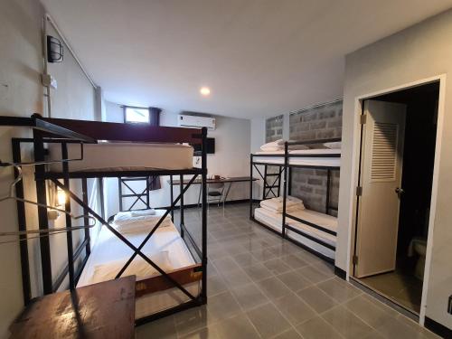 a room with three bunk beds and a hallway at The 8 Factory Hotel Phitsanulok in Phitsanulok