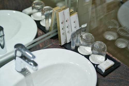baño con espejo y 2 lavabos y gafas en Effotel By Sayaji Dehradun, en Dehradun