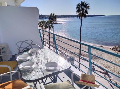 a table on a balcony with a view of the beach at Résidence Armorial in Juan-les-Pins