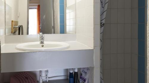 une salle de bain avec un lavabo blanc et un miroir dans l'établissement Les Ondines 2- 15 - Maison duplex- 6 pers, au Cap d'Agde