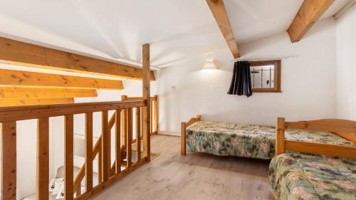 a bedroom with two beds and a staircase in a cabin at Cristallines- 89- Maison mezzanine- 6 pers in Cap d'Agde