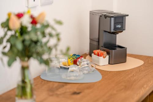 Sarmenti Agriresort في أوترانتو: آلة صنع القهوة على طاولة مع إناء من الزهور