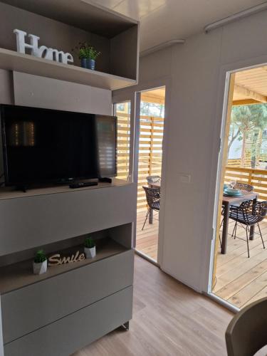 a living room with a flat screen tv and a patio at Mobile Home Sole in Biograd na Moru