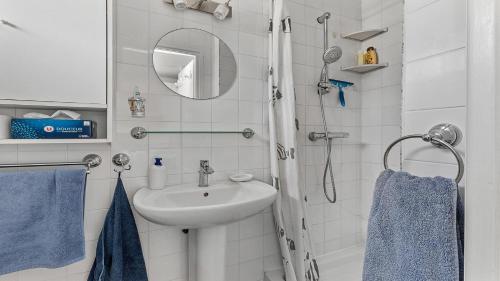 W łazience znajduje się umywalka oraz prysznic z niebieskimi ręcznikami. w obiekcie Sun Village- 39- Maison duplex- 6 pers w Cap d'Agde