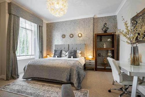a bedroom with a bed and a table and a desk at Carmel Apartments in Falkirk
