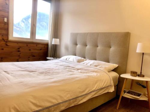 sypialnia z dużym białym łóżkiem i dużym oknem w obiekcie Apartment Bourg St Maurice w mieście Bourg-Saint-Maurice