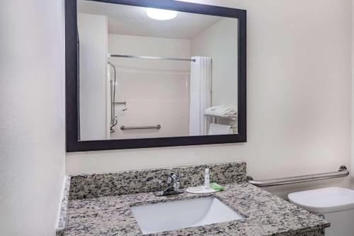 ein Bad mit einem Waschbecken und einem Spiegel in der Unterkunft Super 8 by Wyndham Danville in Danville