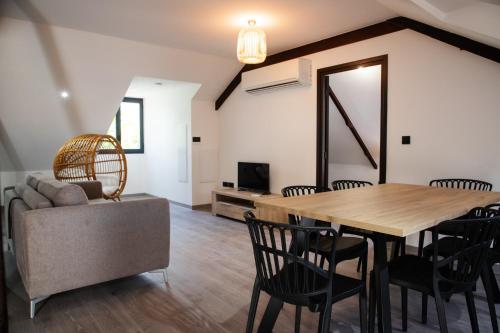 ein Esszimmer mit einem Tisch, Stühlen und einem Sofa in der Unterkunft Villa des 3 sables, MACABI in L'Étang-Salé-les-Bains