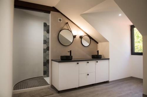 La salle de bains est pourvue d'un lavabo et de 2 miroirs sur le mur. dans l'établissement Villa des 3 sables, MACABI, à Étang-Salé les Bains