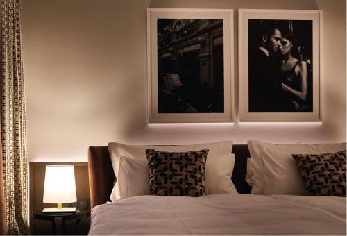 a bedroom with a bed with two pictures on the wall at Clounys Hotel in Hamburg