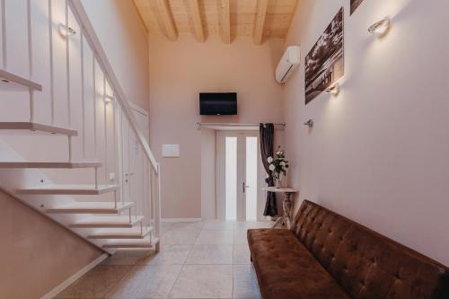 a hallway with a staircase and a couch at Le Due Dame in Manerba del Garda