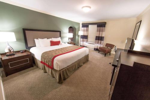 a hotel room with a large bed and a chair at Ramada by Wyndham Houston Intercontinental Airport East in Humble