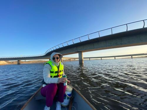 a woman in a boat in the water under a bridge at La Balsa in José Ignacio