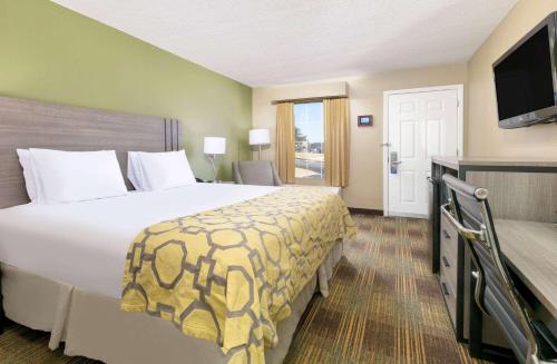 a hotel room with a large bed and a television at Baymont by Wyndham Prattville - Montgomery in Prattville