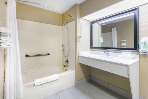 a bathroom with a sink and a tub and a mirror at Baymont by Wyndham Prattville - Montgomery in Prattville