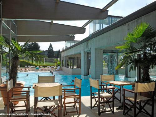 une terrasse avec des tables et des chaises ainsi qu'une piscine dans l'établissement Studio Aix-les-Bains, 1 pièce, 1 personne - FR-1-555-77, à Aix-les-Bains