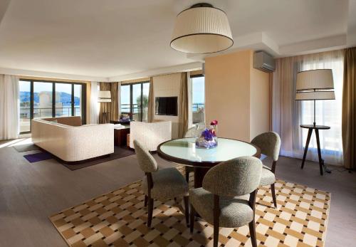 a room with a table and chairs and a living room at Hyatt Regency Nice Palais de la Méditerranée in Nice