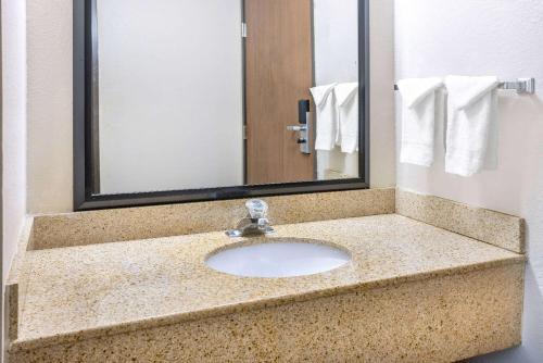 a bathroom counter with a sink and a mirror at Baymont by Wyndham Beloit in Beloit