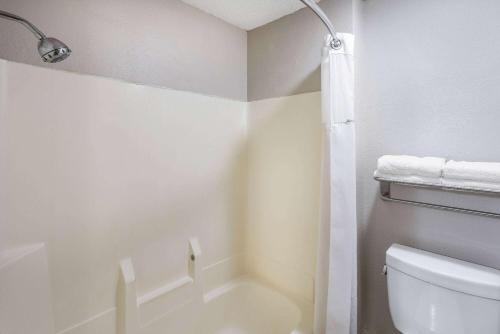 a white bathroom with a toilet and a shower at Baymont by Wyndham Beloit in Beloit