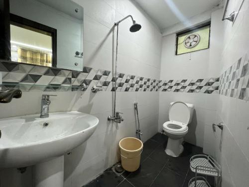 a bathroom with a sink and a toilet at The Realtors Inn Deluxe Cottage Murree in Murree