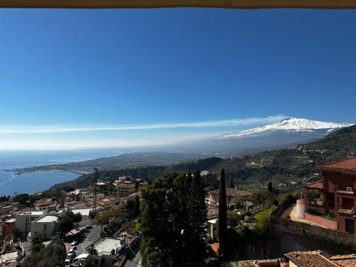 a view of a city with a snow covered mountain at Villa Greta Hotel Rooms & Suites in Taormina