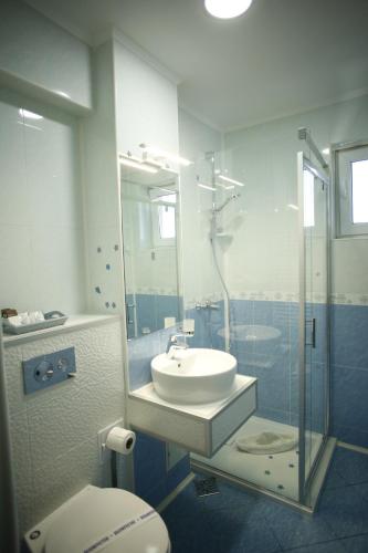 a bathroom with a toilet and a sink and a shower at Casa Coral Mamaia Nord in Mamaia Nord