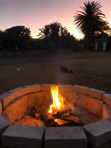 a fire pit with a cat sitting next to it at Bella@Jbay in Jeffreys Bay