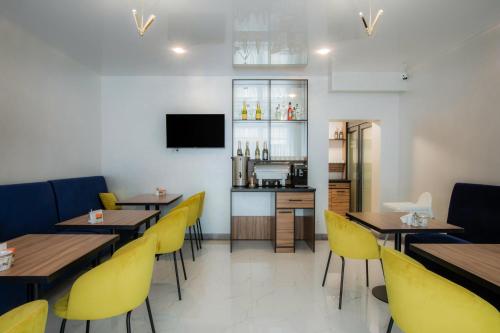 a restaurant with wooden tables and yellow chairs at Salut in Bukovel