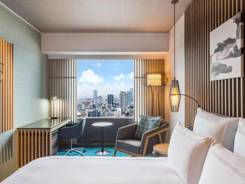 大阪市にあるスイスホテル 南海大阪のベッド付きのホテルルームで、市街の景色を望めます。