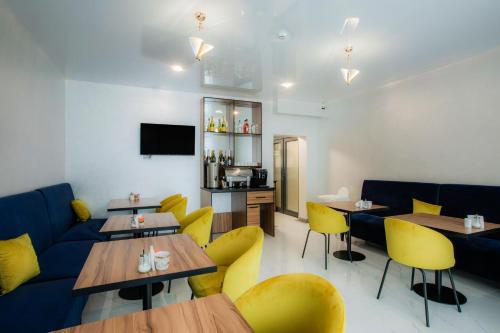 a dining room with tables and yellow chairs at Salut in Bukovel