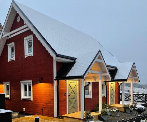 a red house with a black roof at Wioska w Sowich Sokolec in Sokolec