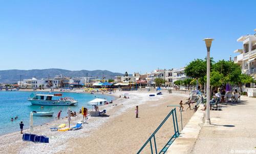 a beach with people and a boat in the water at Sea Breeze 2 in Haraki