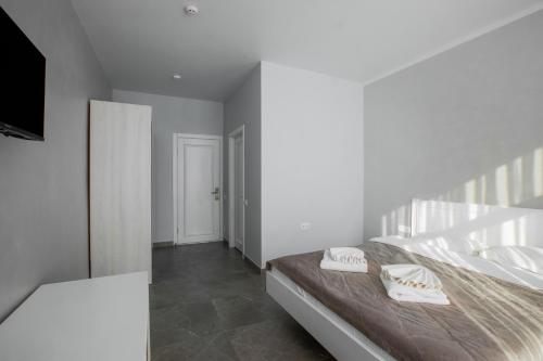 a white bedroom with a bed and a television at Salut in Bukovel