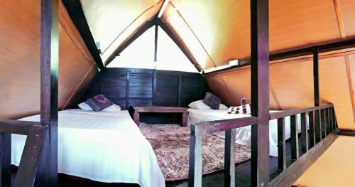 a room with two twin beds in a house at Stargate Villa Pintu Bintang in Pawenang