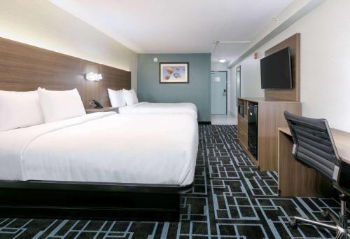 a hotel room with a large bed and a flat screen tv at Baymont by Wyndham Chattanooga Eastridge in East Ridge