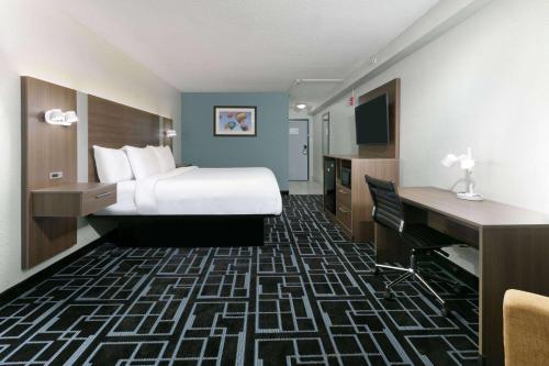 a hotel room with a bed and a desk at Baymont by Wyndham Chattanooga Eastridge in East Ridge
