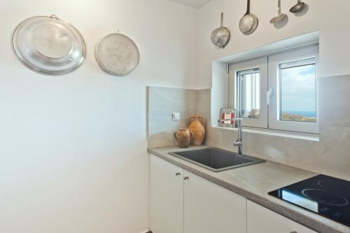 a kitchen with a sink and a window at Blé - Traditional Renovated Cottage in Afiartis