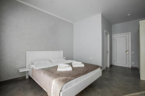 a white bedroom with a bed with two pillows on it at Salut in Bukovel