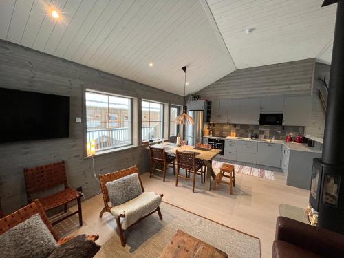 a kitchen and living room with a table and chairs at Funäsdalsporten Funäsdalen in Funäsdalen