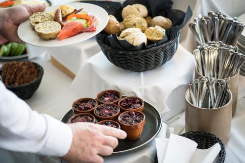 una persona sosteniendo un plato de comida en una mesa en Lübker Golf Resort, en Nimtofte