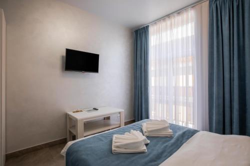 a bedroom with a bed and a tv and a window at Salut in Bukovel