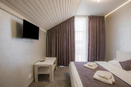 a hotel room with a bed and a television at Salut in Bukovel