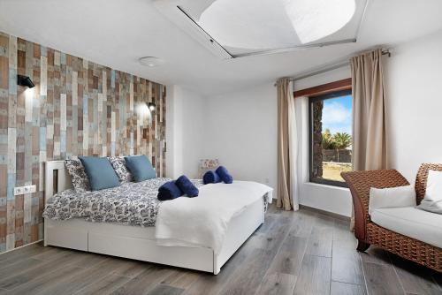 - une chambre avec un lit, une fenêtre et un canapé dans l'établissement La Orilla del Volcán, à Yaiza
