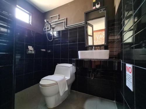 a bathroom with a toilet and a sink and a mirror at The 8 Factory Hotel Phitsanulok in Phitsanulok
