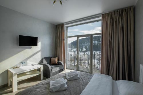 a hotel room with a bed and a large window at Salut in Bukovel