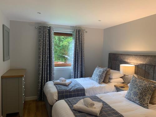 a hotel room with two beds and a window at Lord Galloway 37 with Hot Tub in Newton Stewart