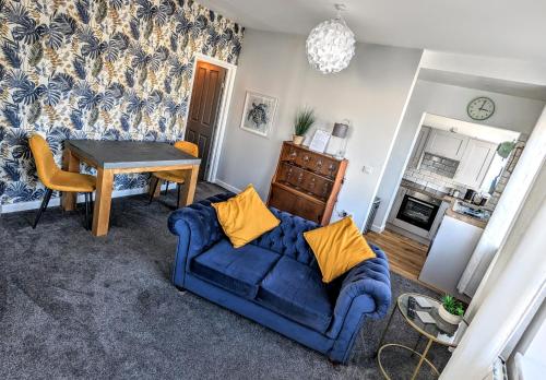 a living room with a blue couch and a table at Spacious contemporary apartment in Ramsgate